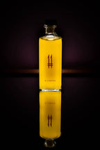 Bottiglia quadrata alta di N.11 Il Limone Il Seduttore con liquore giallo e logo 11 viola