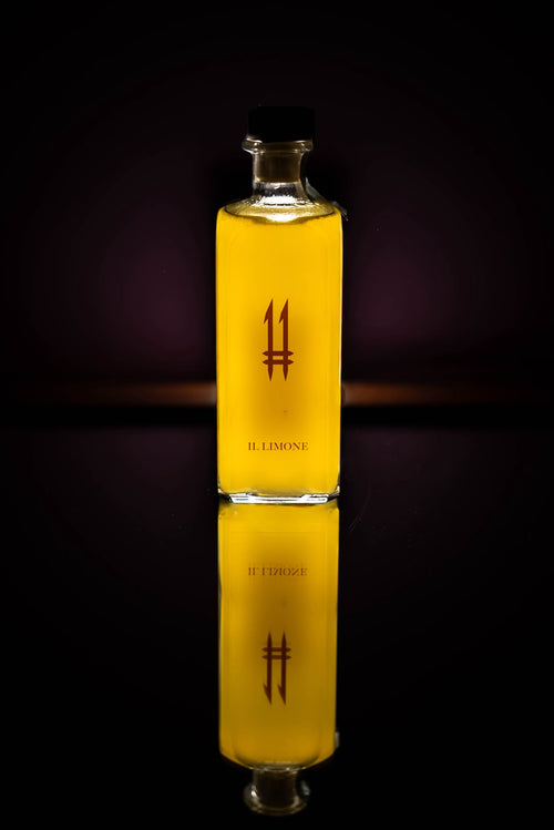 Bottiglia quadrata alta di N.11 Il Limone Il Seduttore con liquore giallo e logo 11 viola