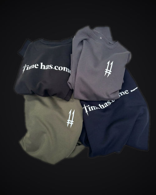 Four N.11 crewneck sweatshirts in black, dark grey, olive green and navy blue, with the 11 logo on the chest and Time has come on the back